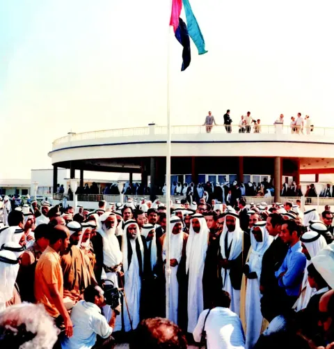 The flag of the Union on its mast at Union House, a crowd in white below it.